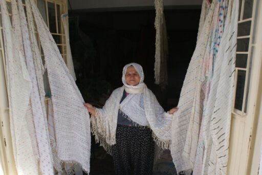 A weaver lady exposing the cotton fabrics that she wove, Üzümlü village, Fethiye, Southwestern Turkey, 2016